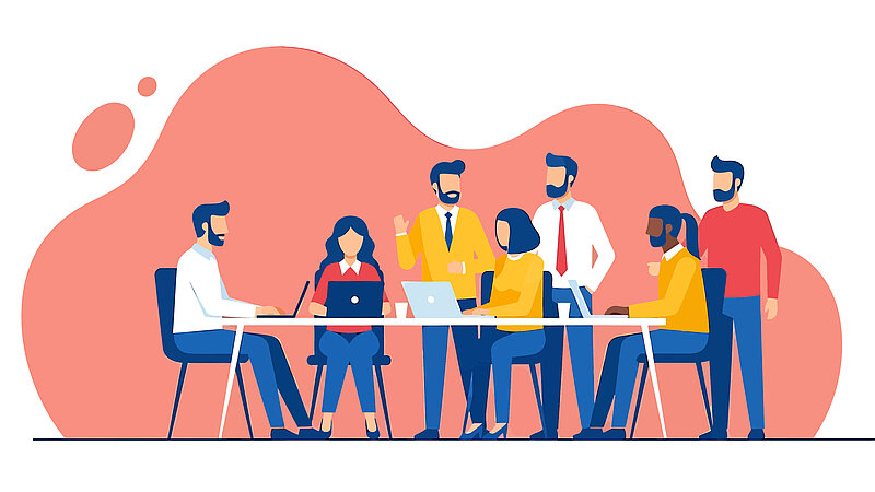 llustration einer Gruppe von sieben Personen in moderner Business-Kleidung, die sich in einer produktiven Besprechung befinden. Drei Personen sitzen an einem weißen Tisch und arbeiten an Laptops, während vier weitere Personen um sie herum stehen, gestikulieren und sich unterhalten. Der Hintergrund besteht aus einer großen, abstrakten, korallfarbenen Form auf weißem Grund.