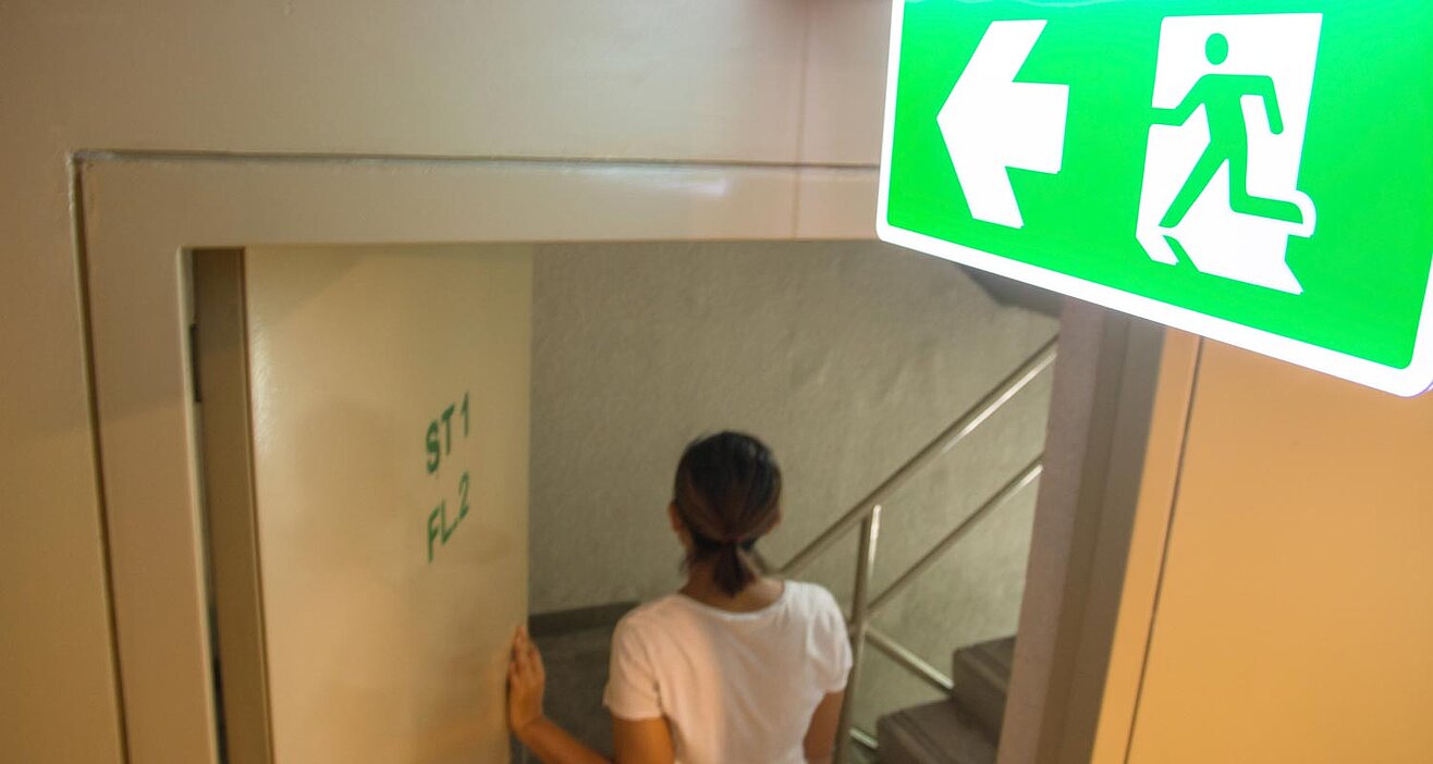 Frau geht durch Notausgang