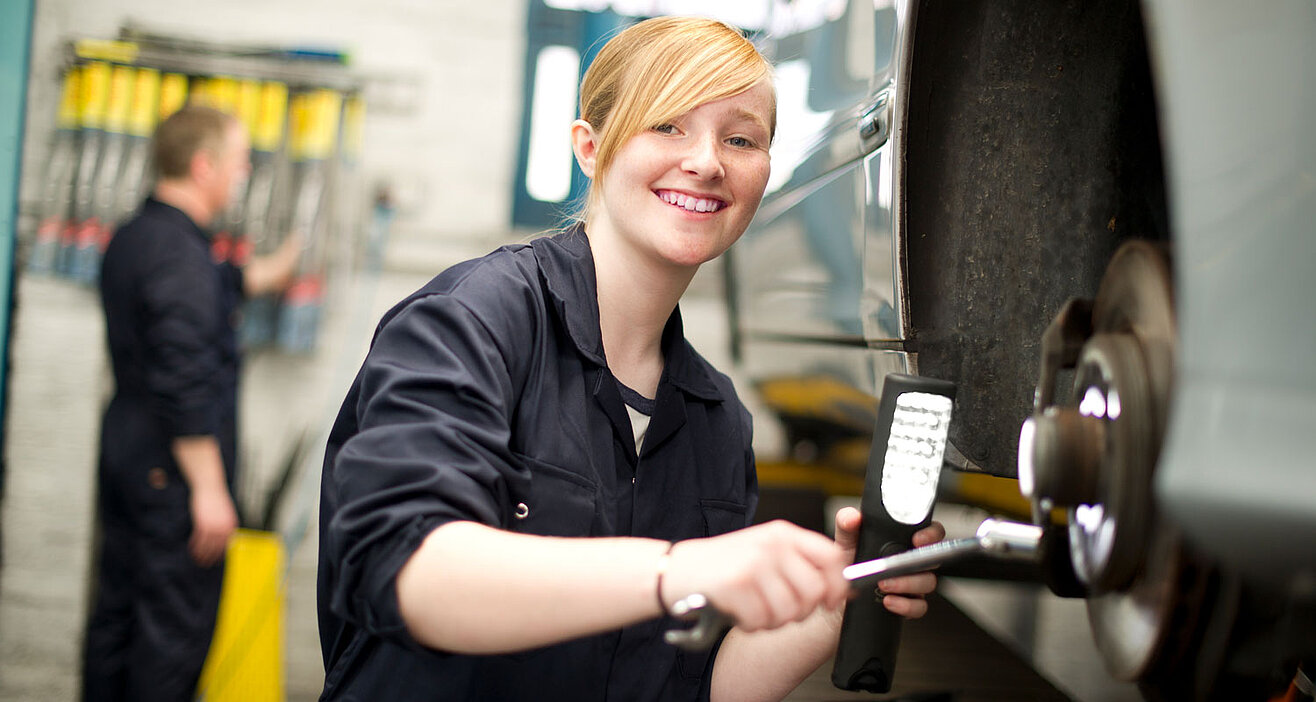 Schülerin arbeitet in einer Autowerkstatt