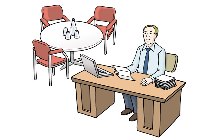 Ein Mann sitzt am Schreibtisch in seinem Büro.