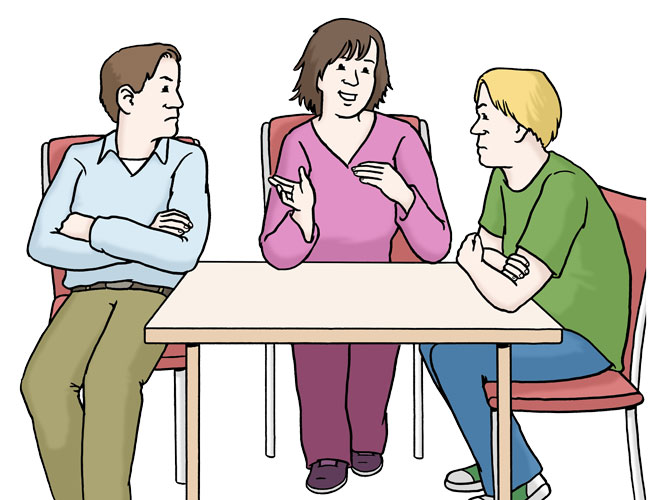 Drei Personen unterhalten sich an einem Tisch