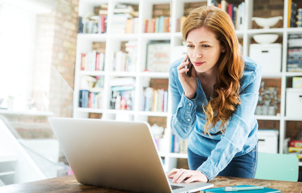Frau arbeitet im Homeoffice und telefoniert.