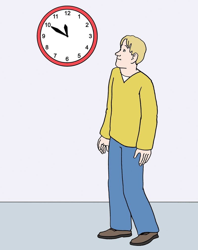 Ein Mann steht vor einer Uhr. 
