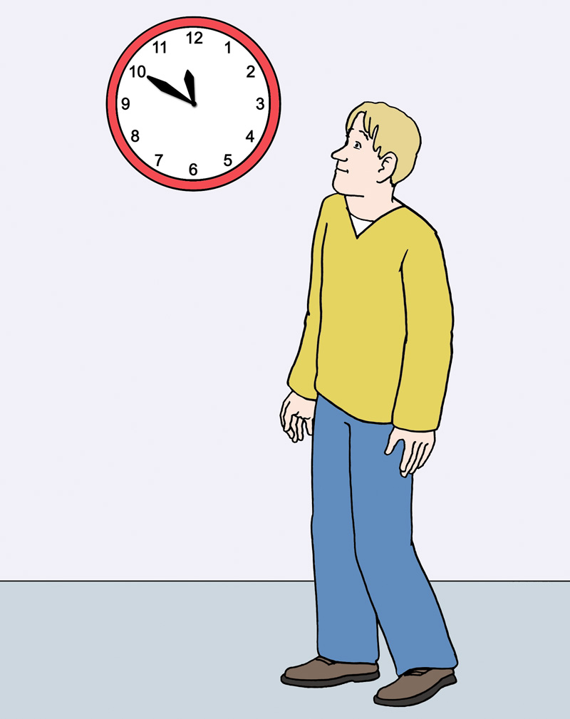 Ein Mann steht vor einer Uhr.