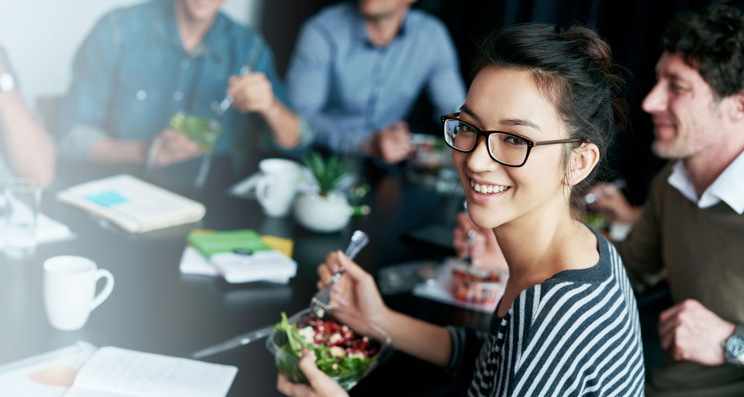 Frau isst Salat im Büro