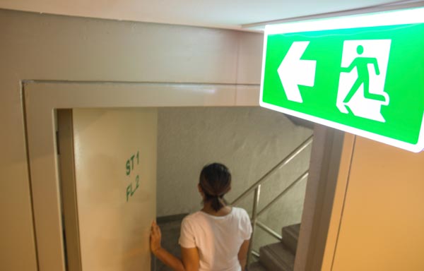 Frau geht durch Notausgang